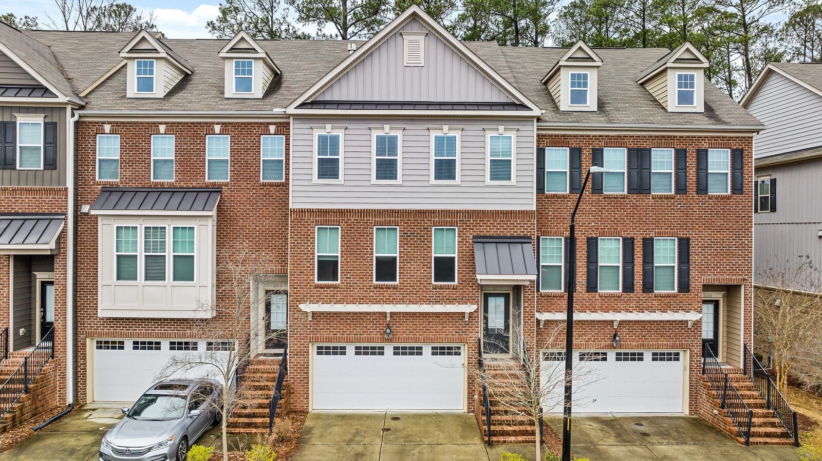 Finished New England brick-and-siding multifamily townhome community by Patriot Carpentry