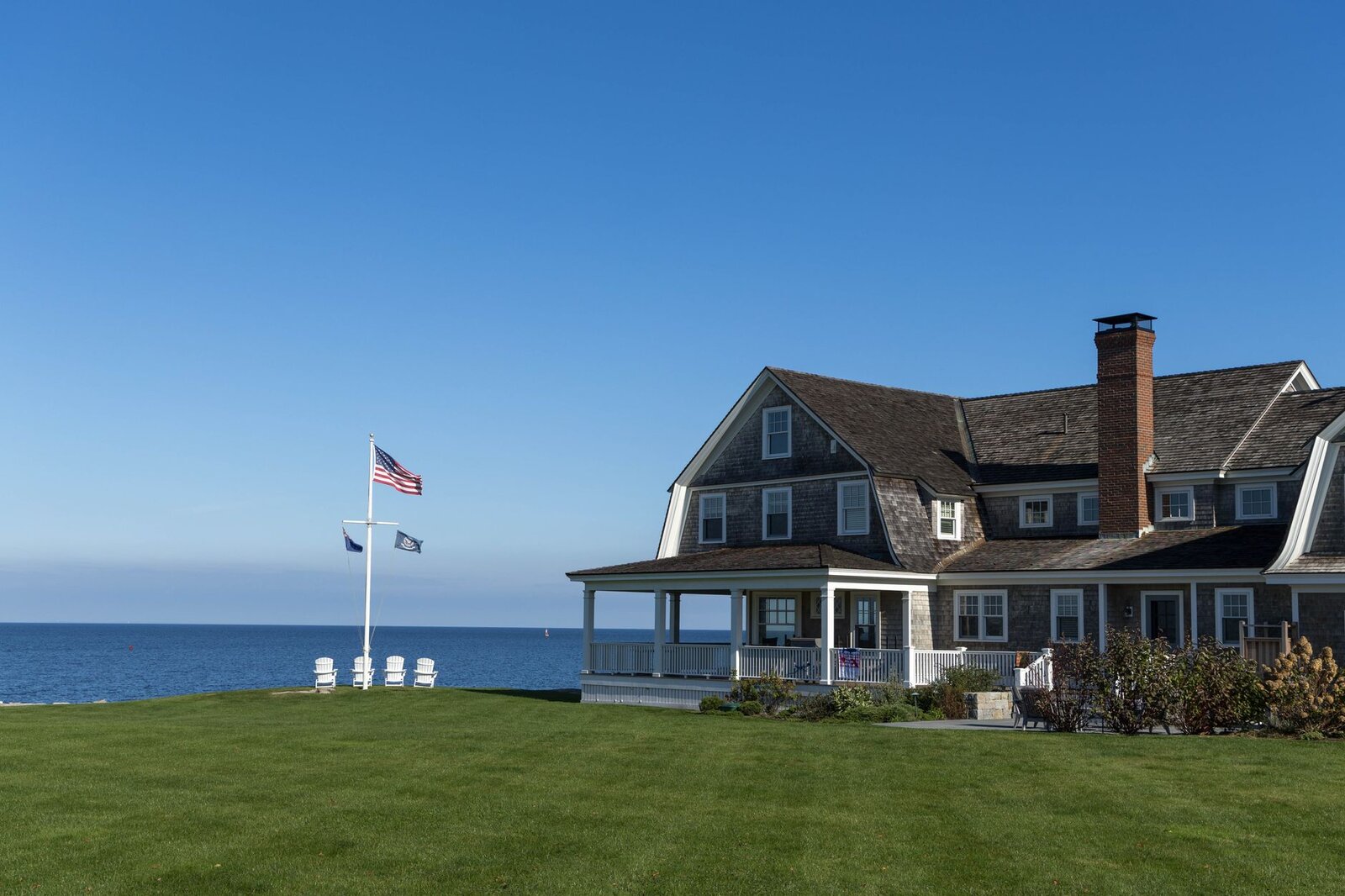 Classic New England shingle-style home with a wraparound covered porch